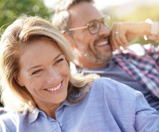 Smiling middle-aged couple sitting outside